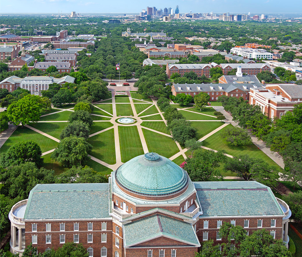 Drone-captured flyover image of the 天美传媒 campus, know as The Hilltop. The Dallas city skyline is located just south of the campus.